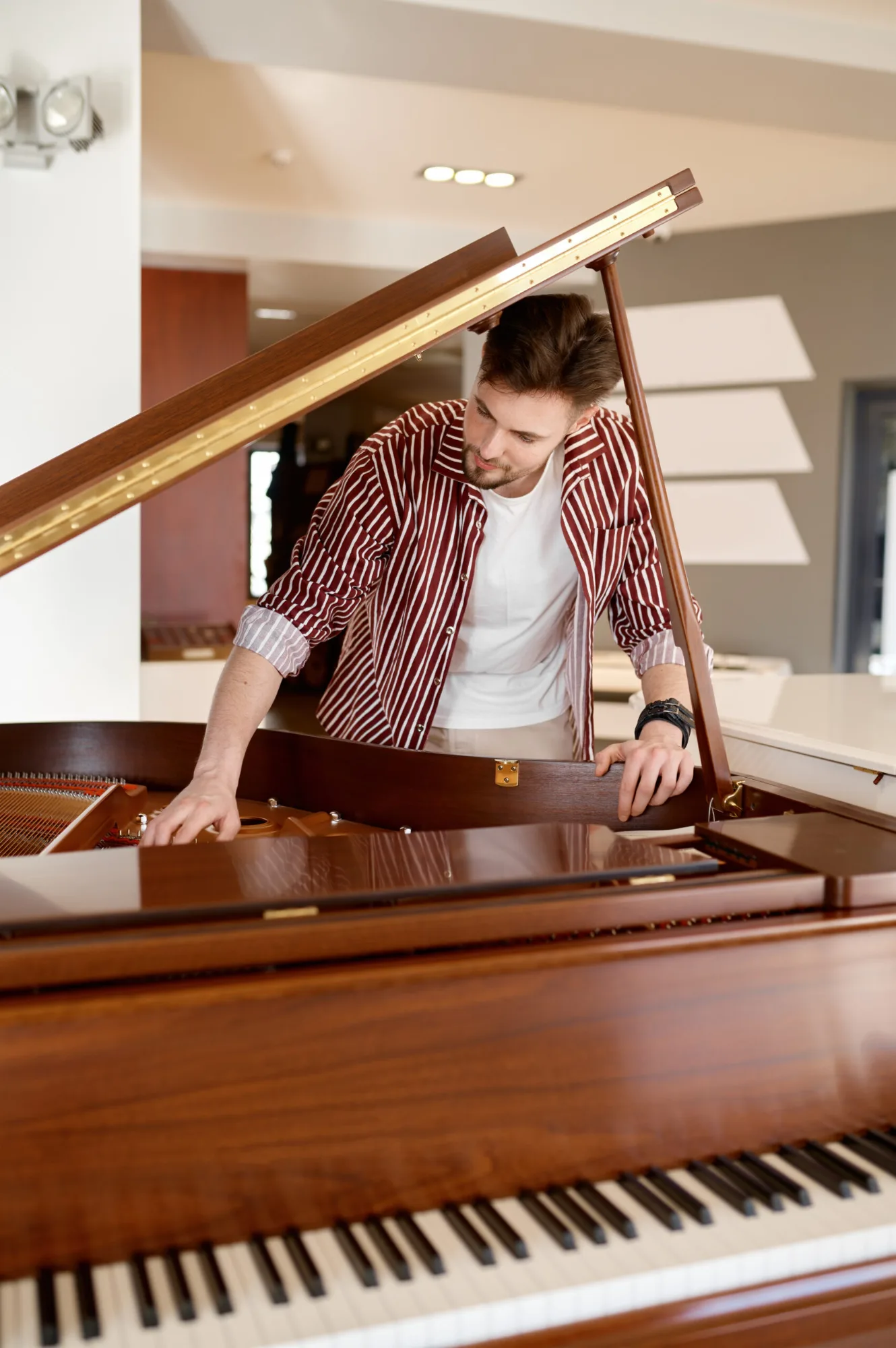 young man examining piano interior in home 2026 03 16 02 26 34 utc